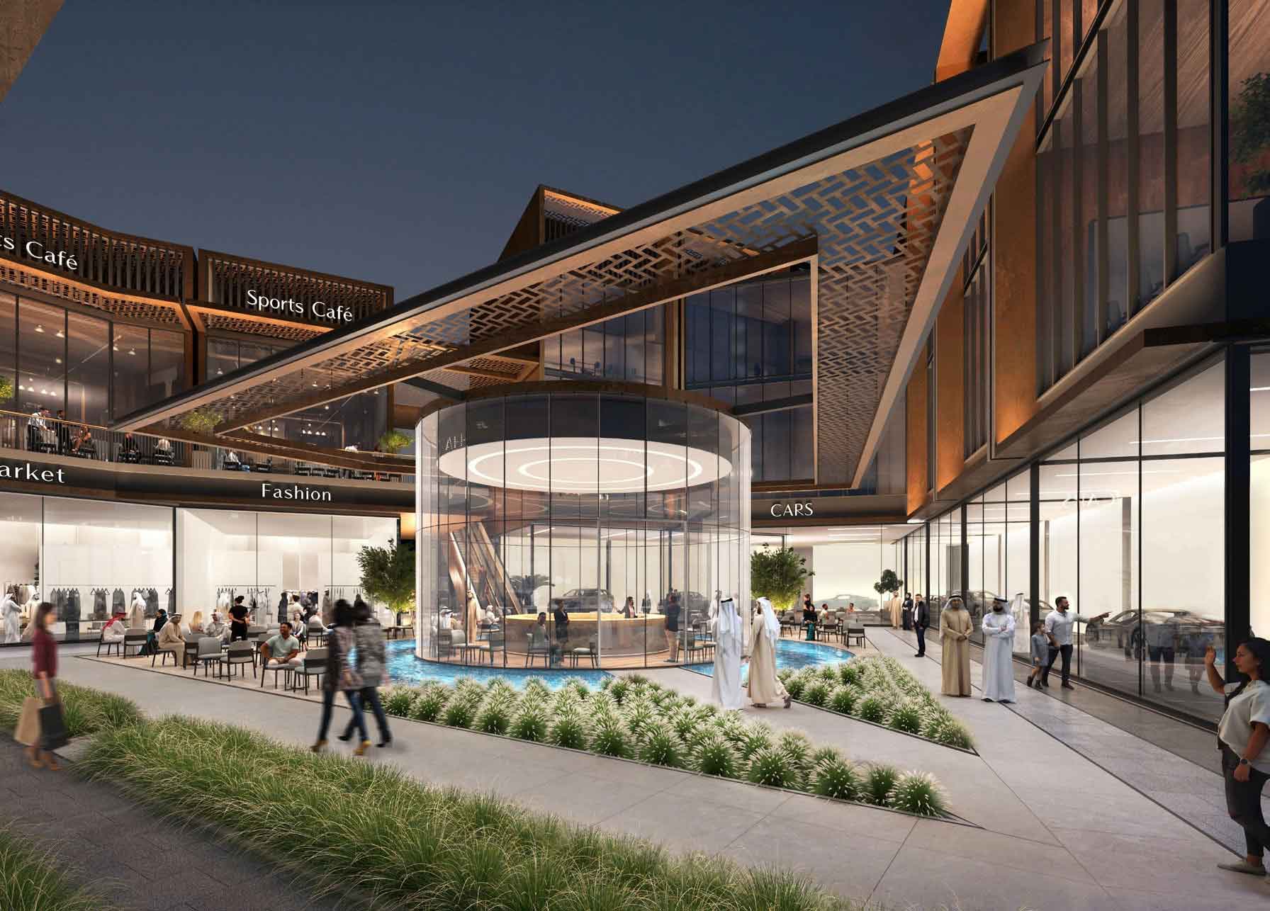 Modern outdoor shopping center at night, featuring a glass-walled circular café surrounded by greenery. Showcasing upscale shops, it captures the vibrant lifestyle that makes Dubai Real Estate and flats in Dubai so desirable.